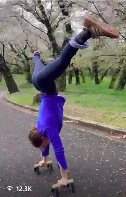Female athlete doing handstand on parallettes