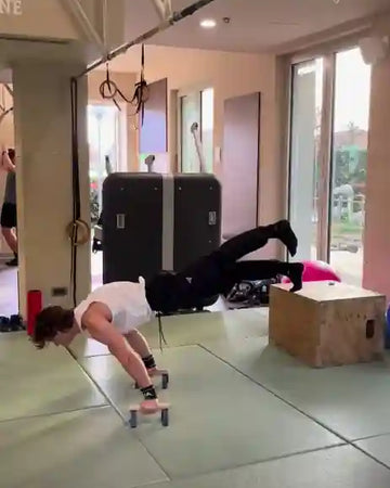 Athlete doing walking planche on parallettes