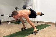 Athlete doing full planche on parallettes