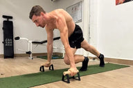 Athlete doing mountain climber on parallettes