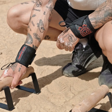 Person with tattoos holding parallettes outdoors