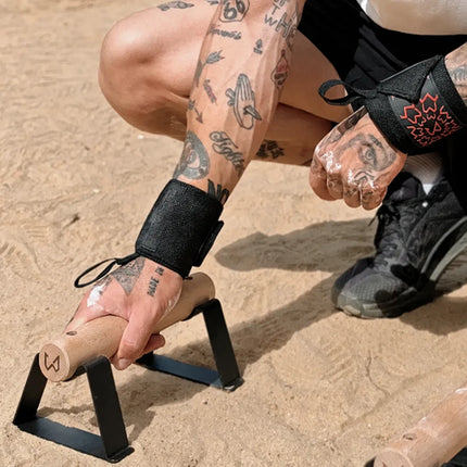A close-up lifestyle shot of an athlete holding parallettes