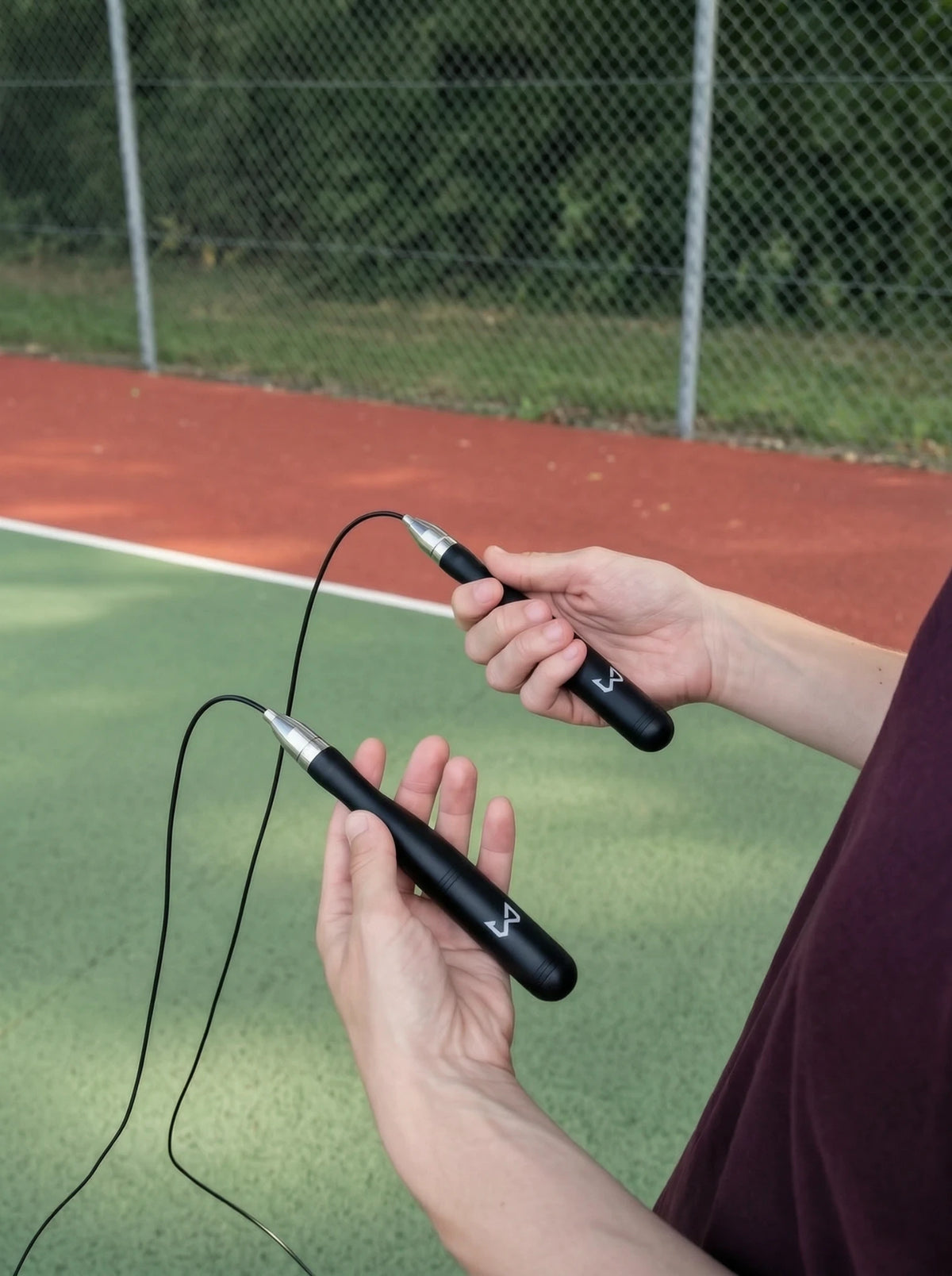Person holding a jump rope with graffiti in the background