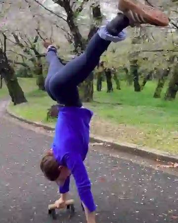 Female athlete doing handstand on parallettes