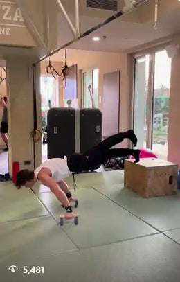 Athlete doing walking planche on parallettes