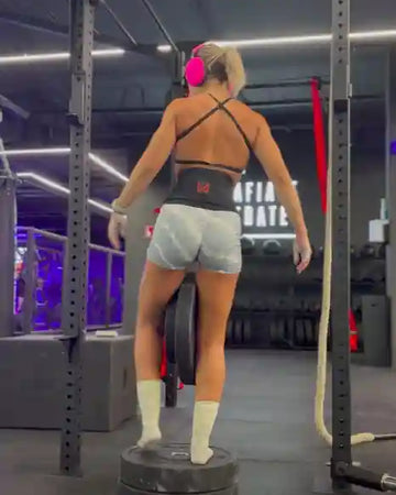 Female athlete using dip belt to do pull-ups