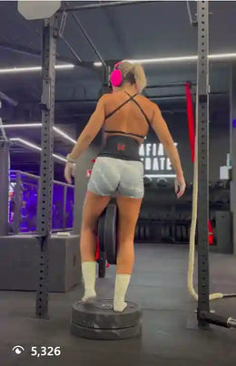 Female athlete using dip belt to do pull-ups